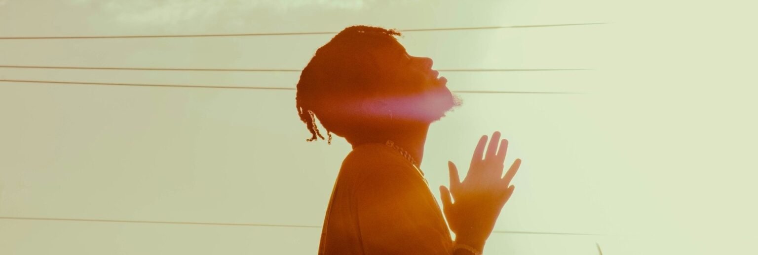 Man praying outside with his face tilted up
